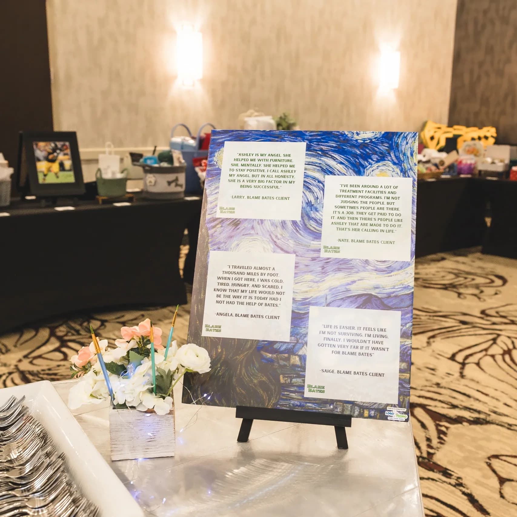 An easel at the gala displaying printed testimonials from Blame Bates clients.